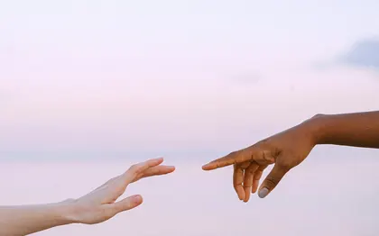 Two hands reaching toward each other