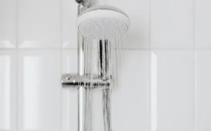 A walk in shower with a handheld head