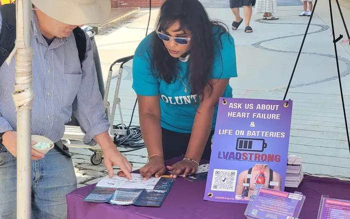 An LVADStrong volunteer laying out materials at a community outreach table