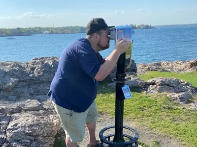 Phil looking out over the water with binoculars